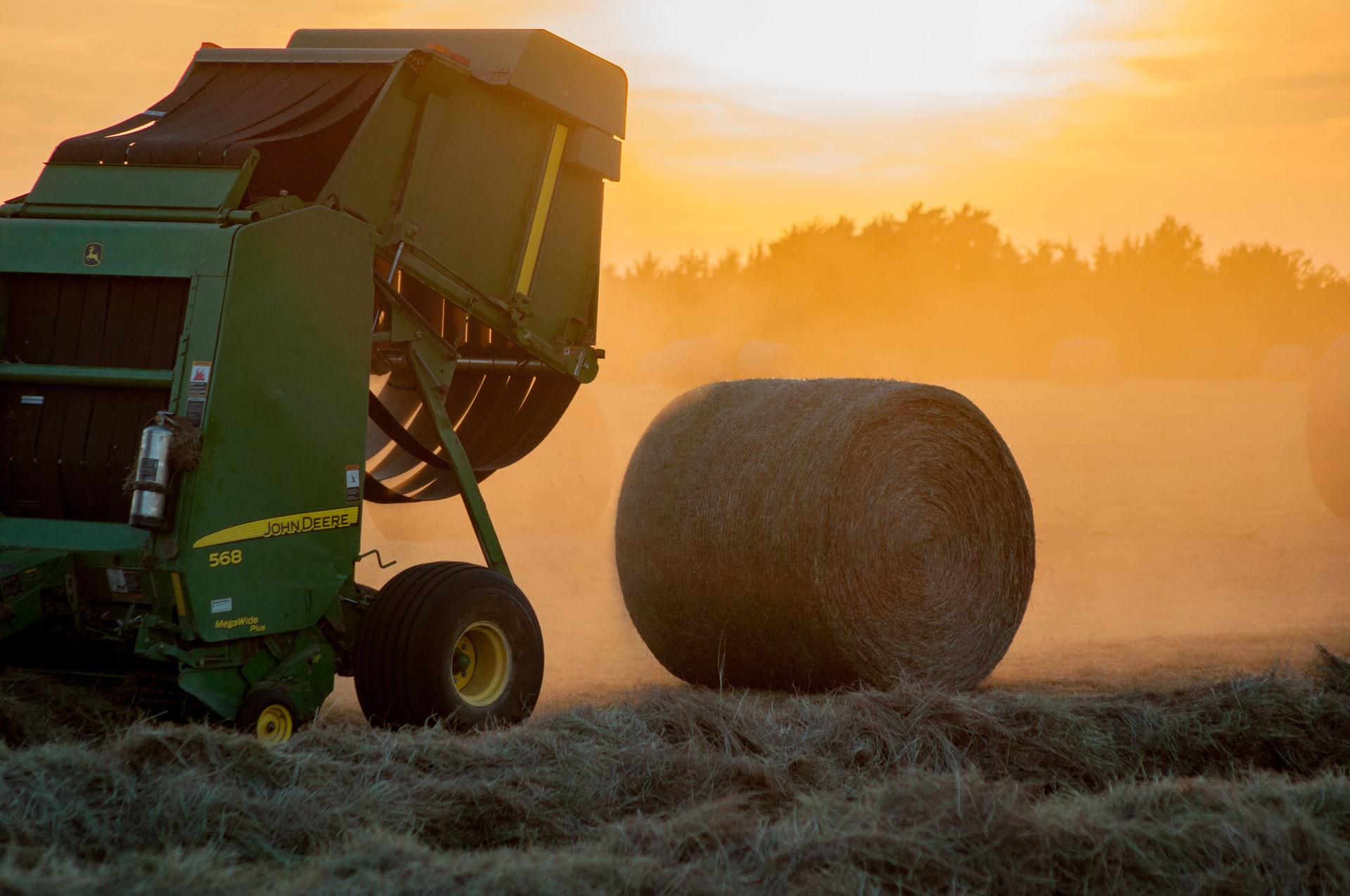 green baler compressing crops into compact bale