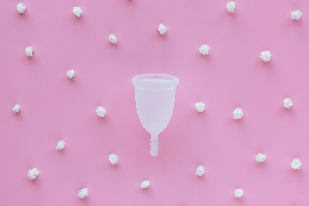 copa menstrual en fondo rosa minimalista