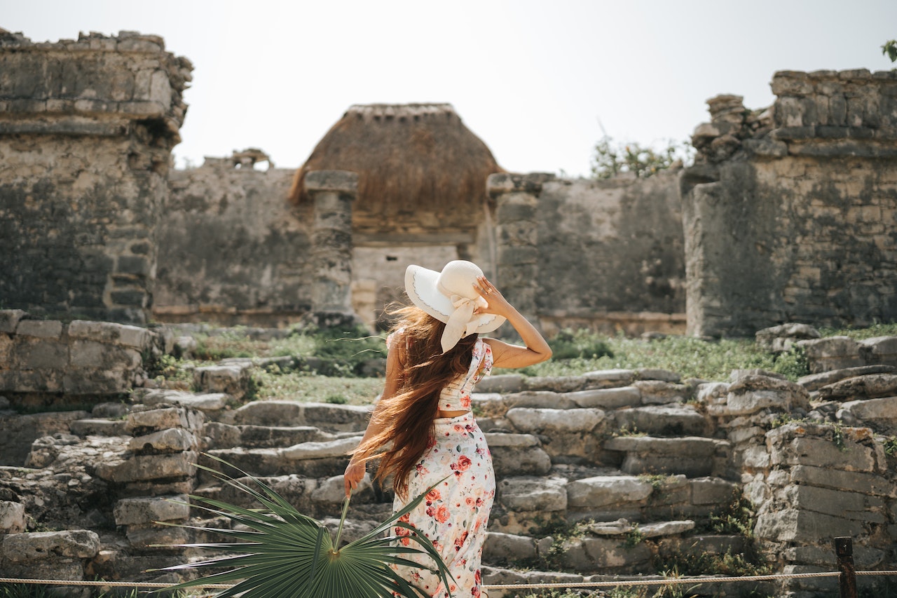Mujer posa de espaldas en unas ruinas históricas mexicanas