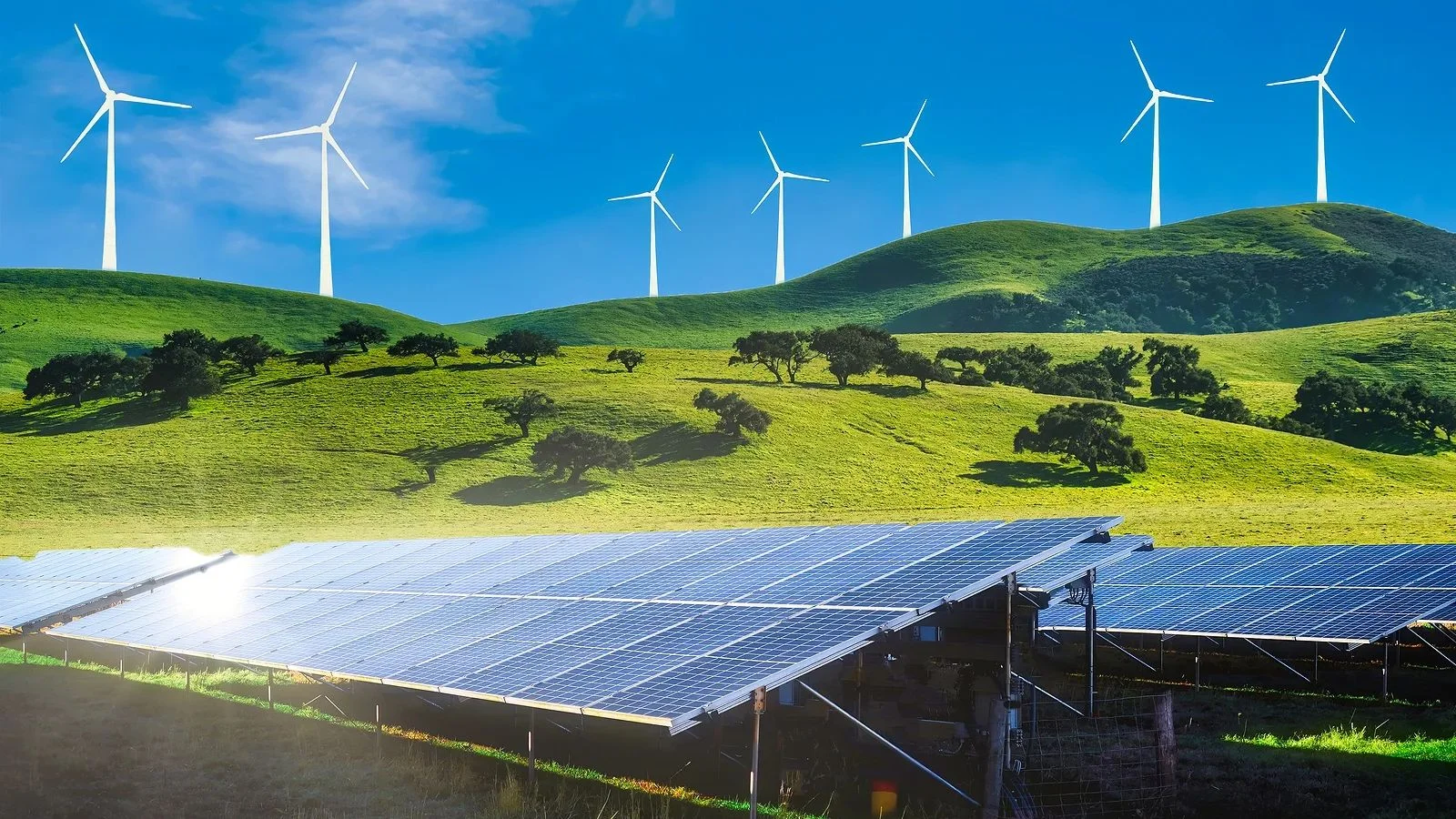 Aerogeneradores y paneles solares en un valle verde