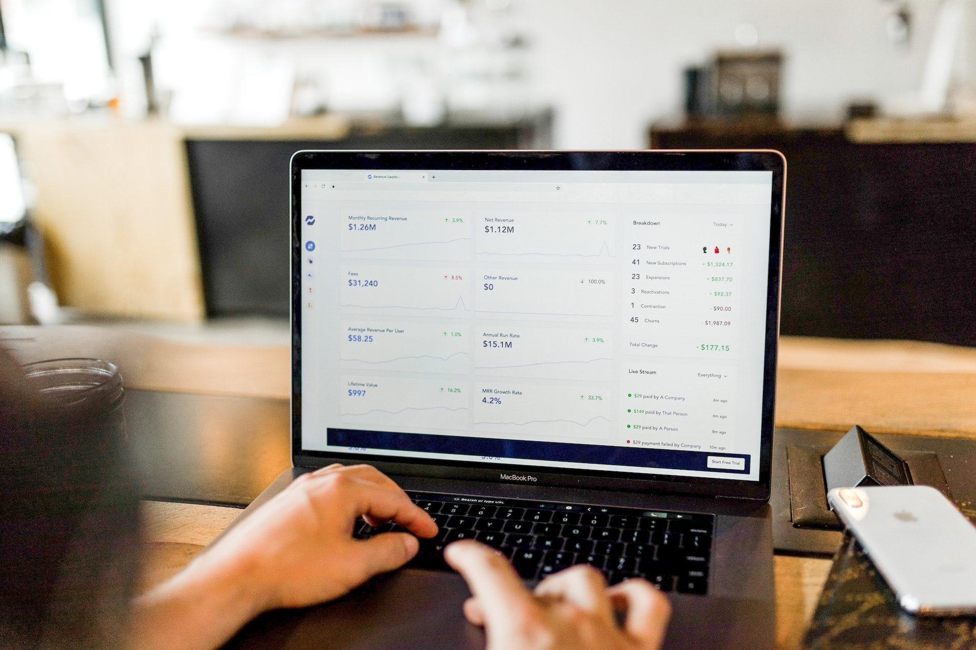 hands on a laptop keyboard with revenue numbers on screen hands on a laptop keyboard with revenue numbers on screen