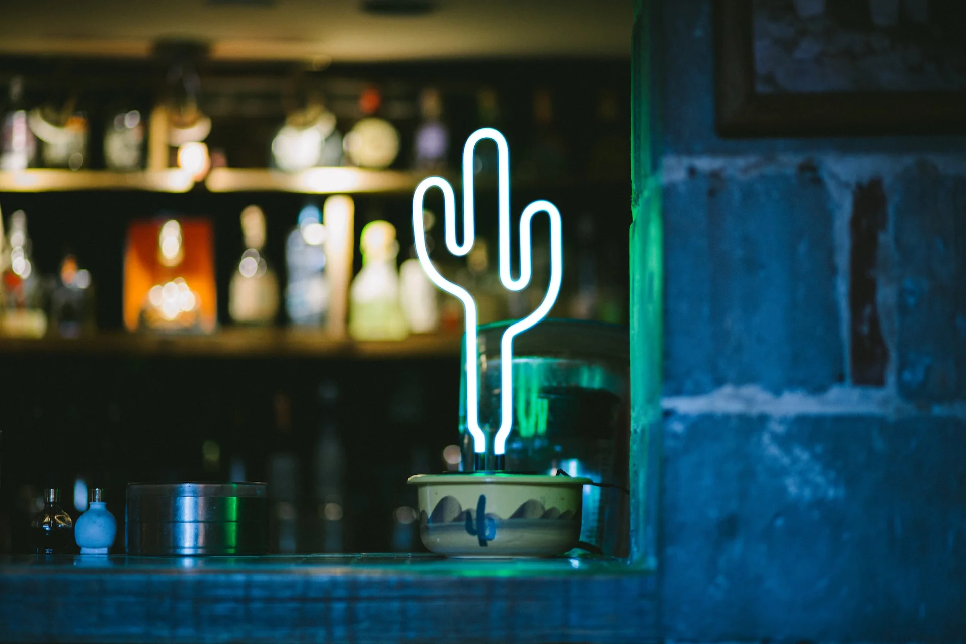 Un cactus verde neón en la ventana de un restaurante mexicano Un cactus verde neón en la ventana de un restaurante mexicano