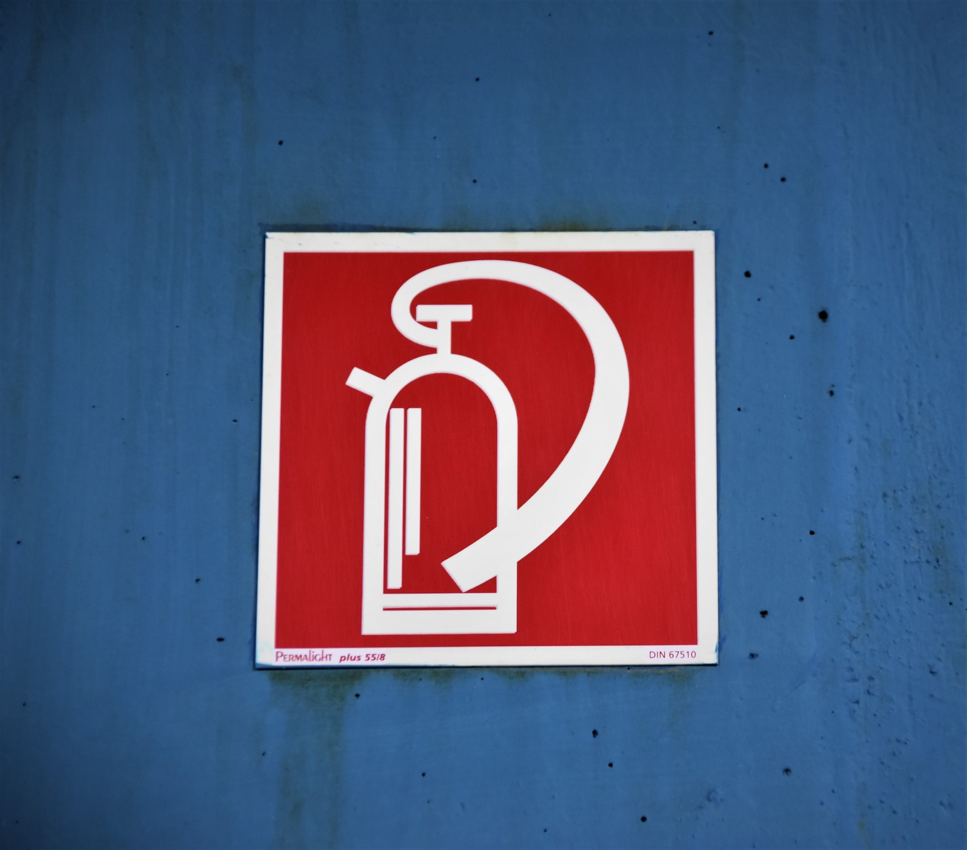 Señal de extintor en una pared azul industrial