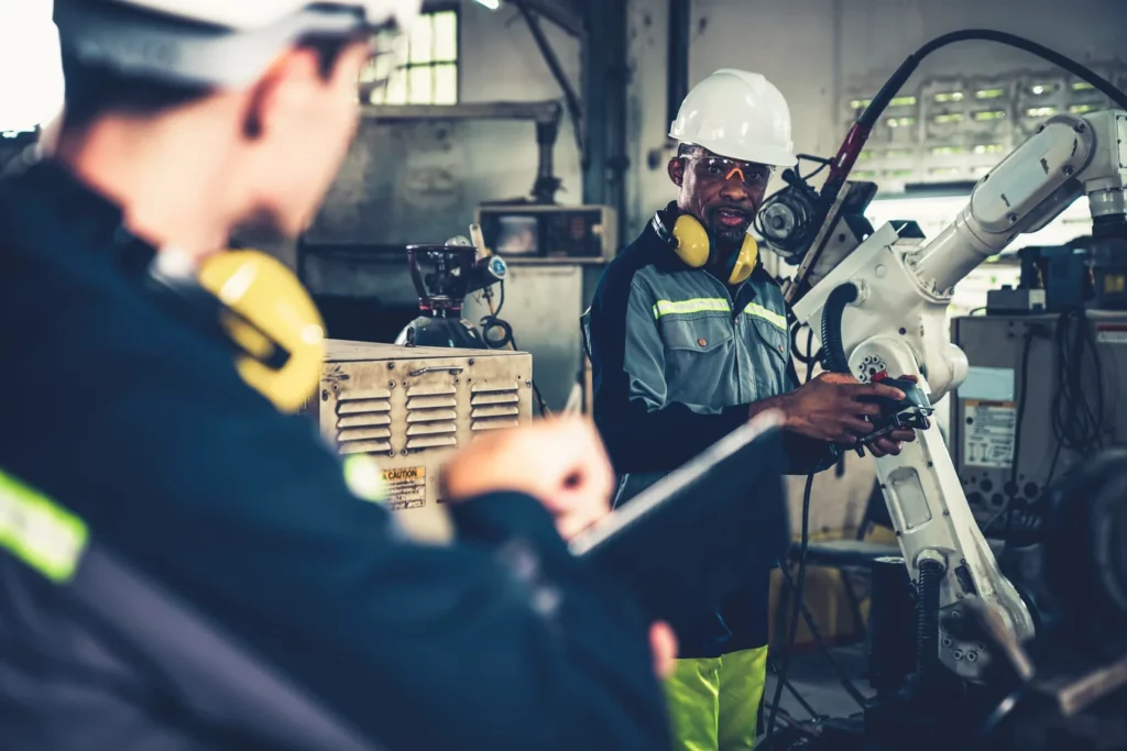 Two workers performing a task together using handheld devices