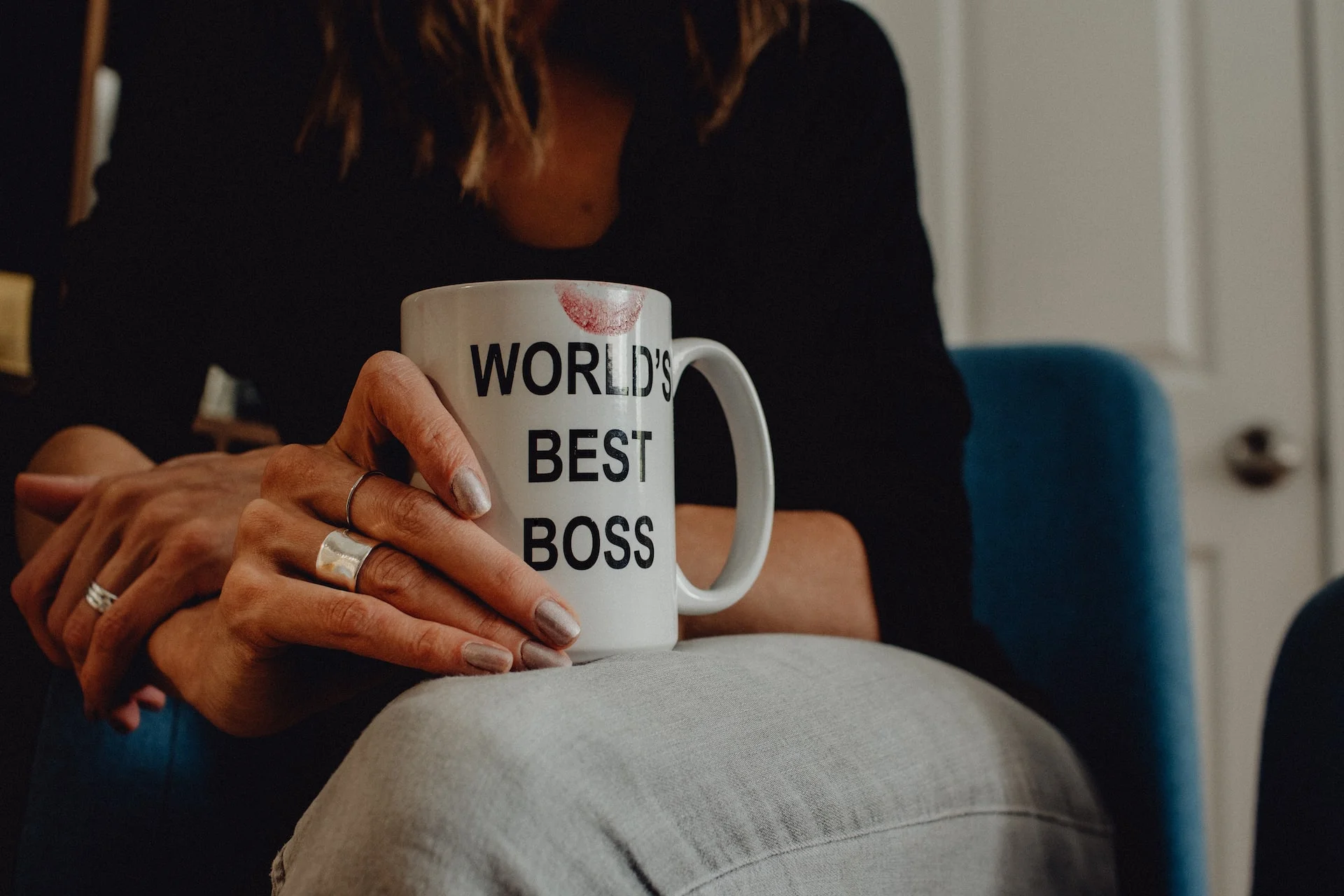 woman holding world's best boss mug with lipstick stain woman holding world's best boss mug with lipstick stain