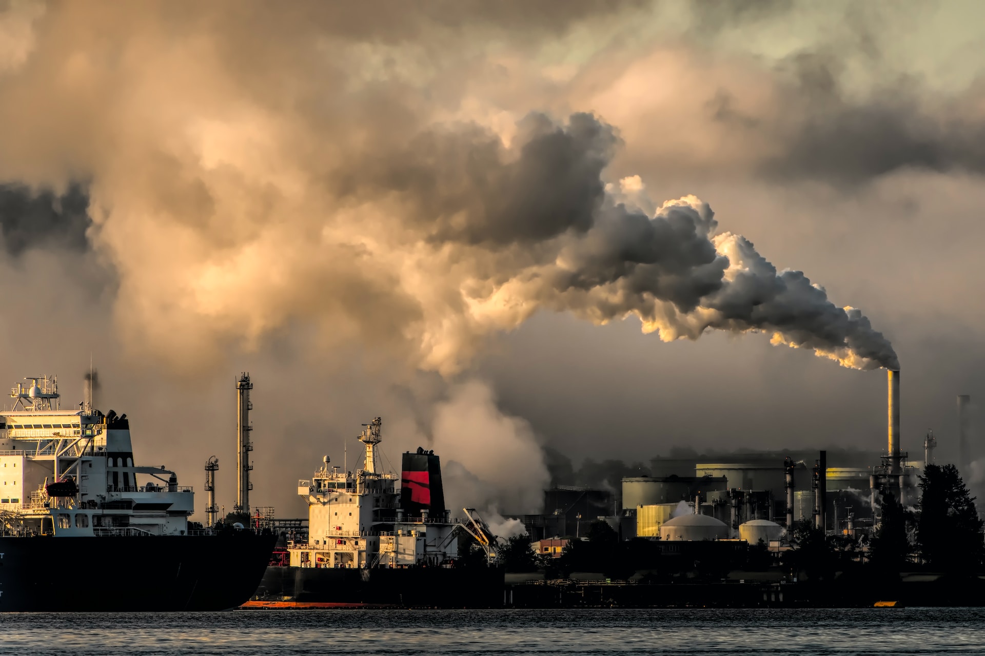 Pollution de l'environnement par les grandes industries Au bord de l'eau, les cheminées des grandes usines fument.