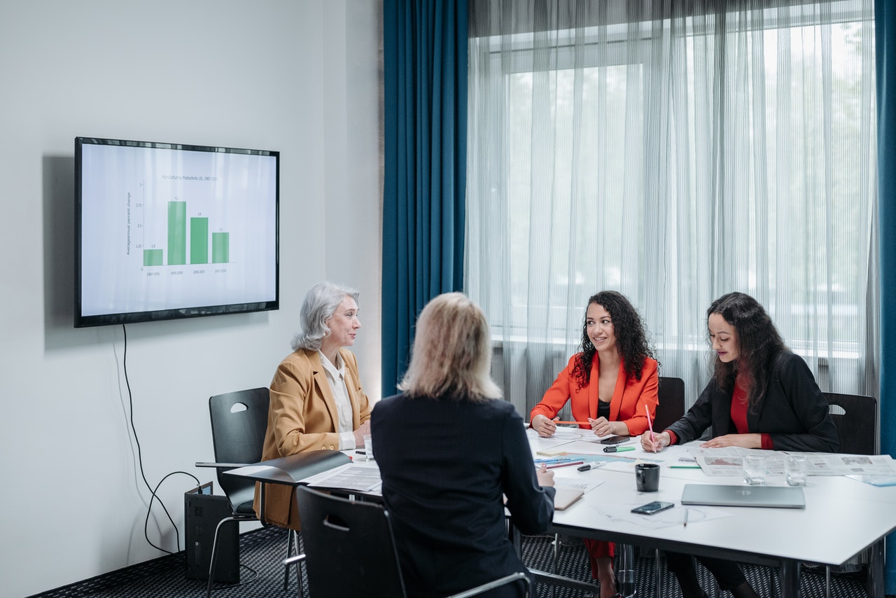 Grupo de mujeres hablando en un salon de juntas
